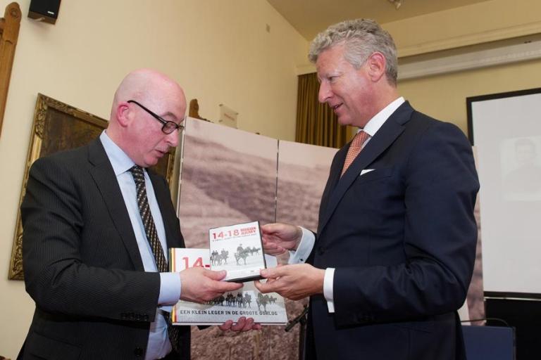 Le ministre de la Défense, Pieter De Crem, remet un exemplaire du livre et du film .